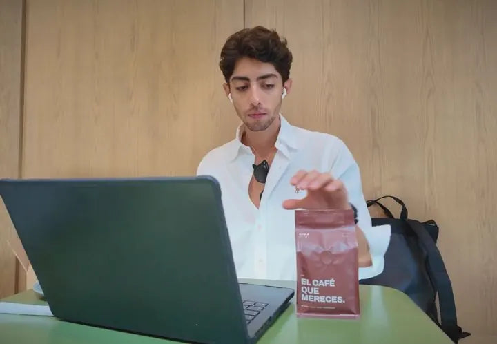 Horacio en su computadora, con una bolsa de CIMA en la mesa